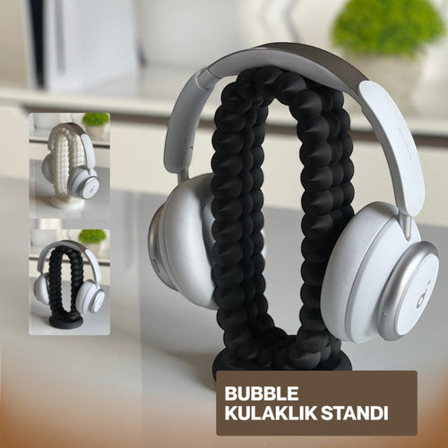 Magicland 3D bubble headphone stand in black, holding white headphones. Unique flexible design.