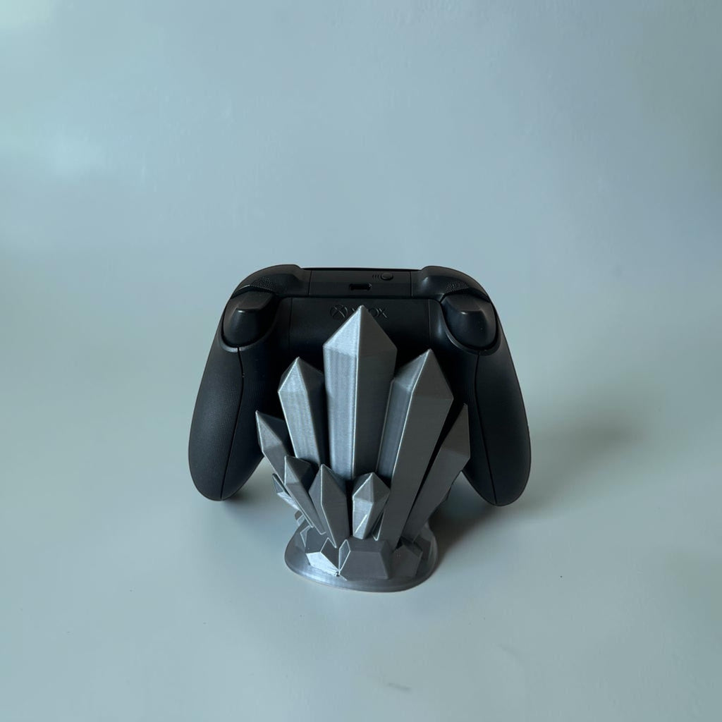 Magicland 3D crystal-design controller stand in silver, holding a black Xbox controller. Unique gaming accessory.