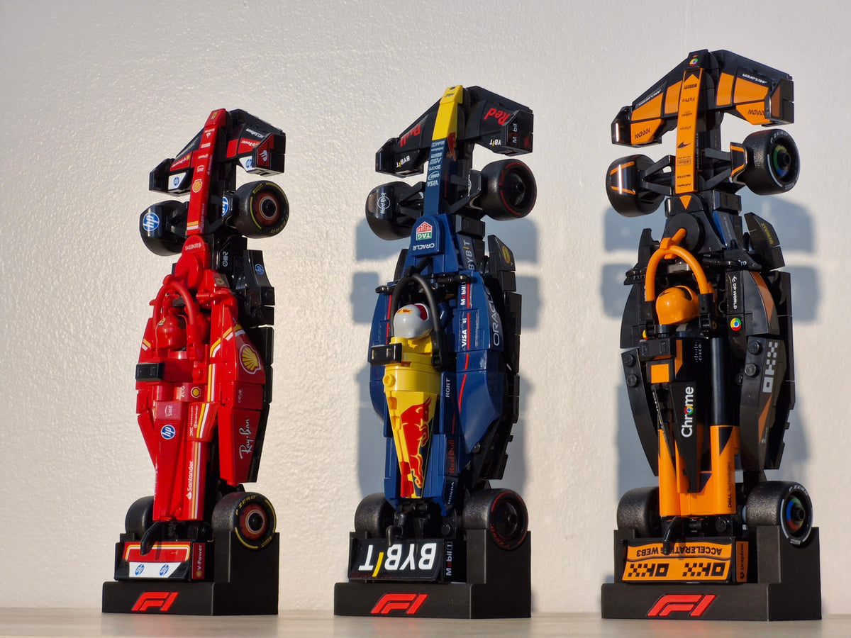 Magicland 3D F1 Lego Speed Champions dikey stant, kırmızı, mavi ve turuncu renklerde üç adet yarış arabası modeli.