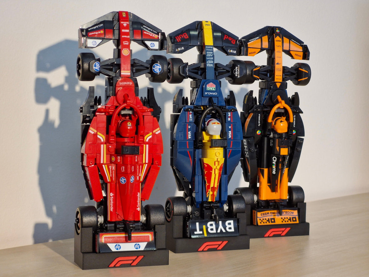 Magicland 3D F1 Lego Speed Champions dikey stant, kırmızı, lacivert ve turuncu renkli üç adet yarış arabası modeli.