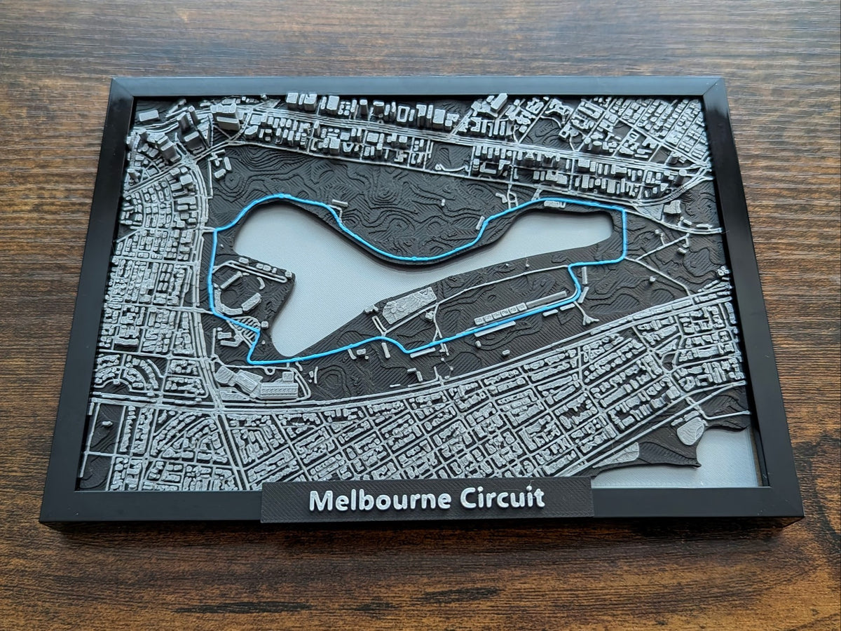 Magicland 3D F1 Melbourne Circuit 3D kabartma haritası, siyah ve gri tonlarda, mavi yarış çizgisi detayı.