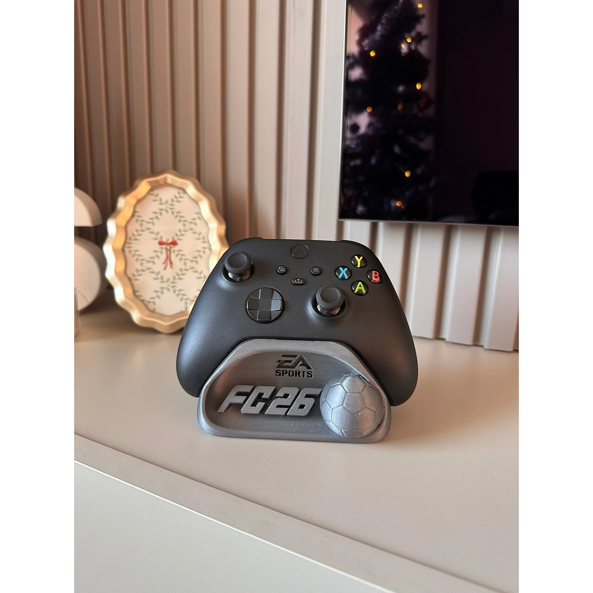 Magicland 3D FC26 Kol Tutucu Stant, Xbox oyun kumandası için tasarlanmış, üzerinde FC26 ve futbol topu figürü bulunan gümüş renkli stand.