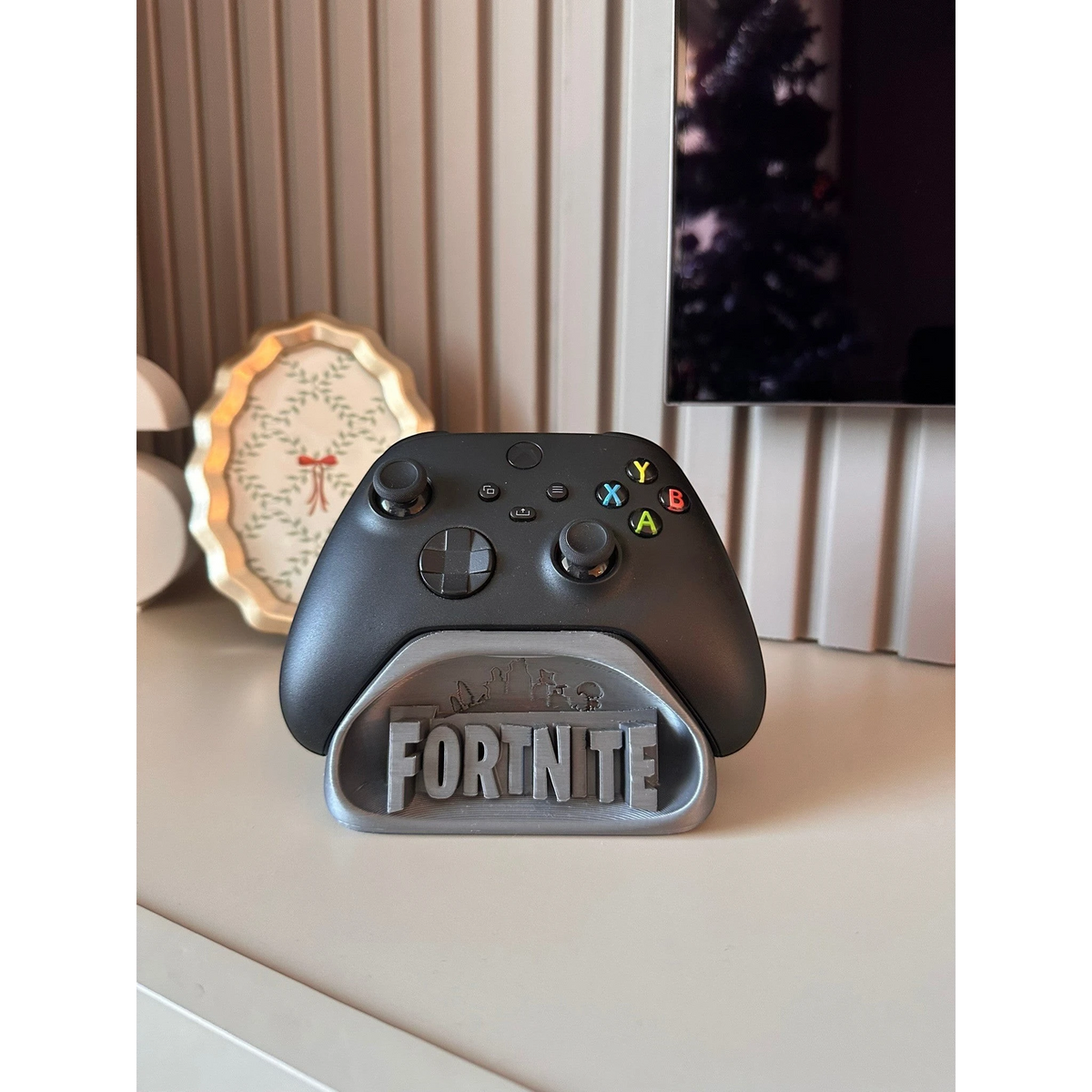 Magicland 3D Fortnite temalı gri renkli oyun kumandası tutucu stant. Kumanda standı üzerinde "FORTNITE" yazısı ve oyun içi figürler bulunmaktadır.
