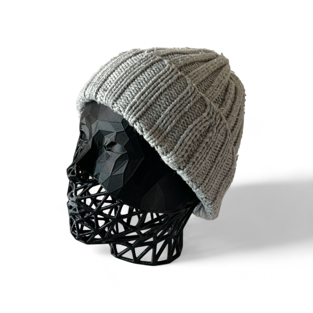 Magicland 3D grey knitted beanie with ribbed texture displayed on a black geometric head stand.