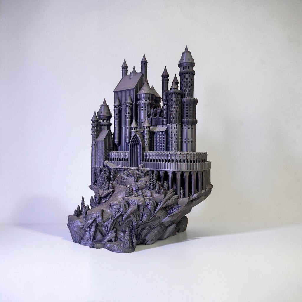 Magicland 3D Hogwarts dekoratif figür, gri renkli, detaylı bir şato maketi, kayalık zemin üzerinde ağaçlarla süslenmiş.