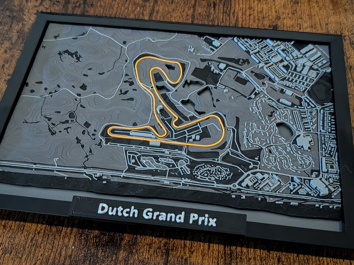 Magicland 3D, Hollanda Grand Prix pistinin kabartmalı 3 boyutlu haritası, turuncu renkte vurgulanmış pist ve gri tonlamalı arazi detayları.