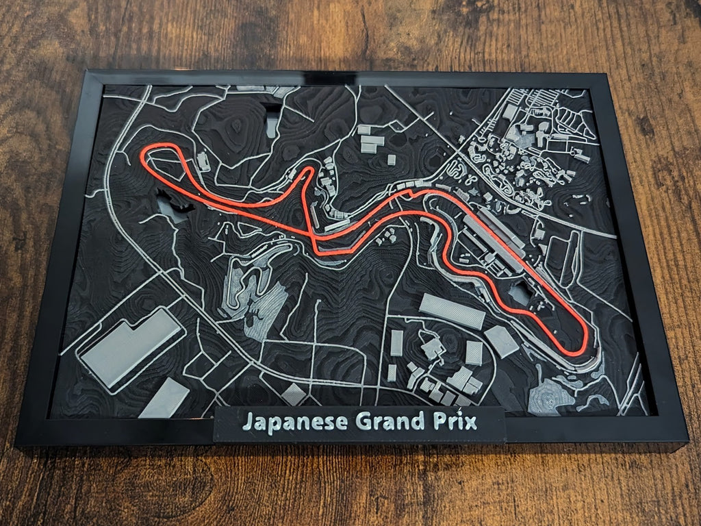 Magicland 3D 3 boyutlu Japonya Grand Prix pist haritası, siyah zemin üzerinde parlak turuncu pist detayı.