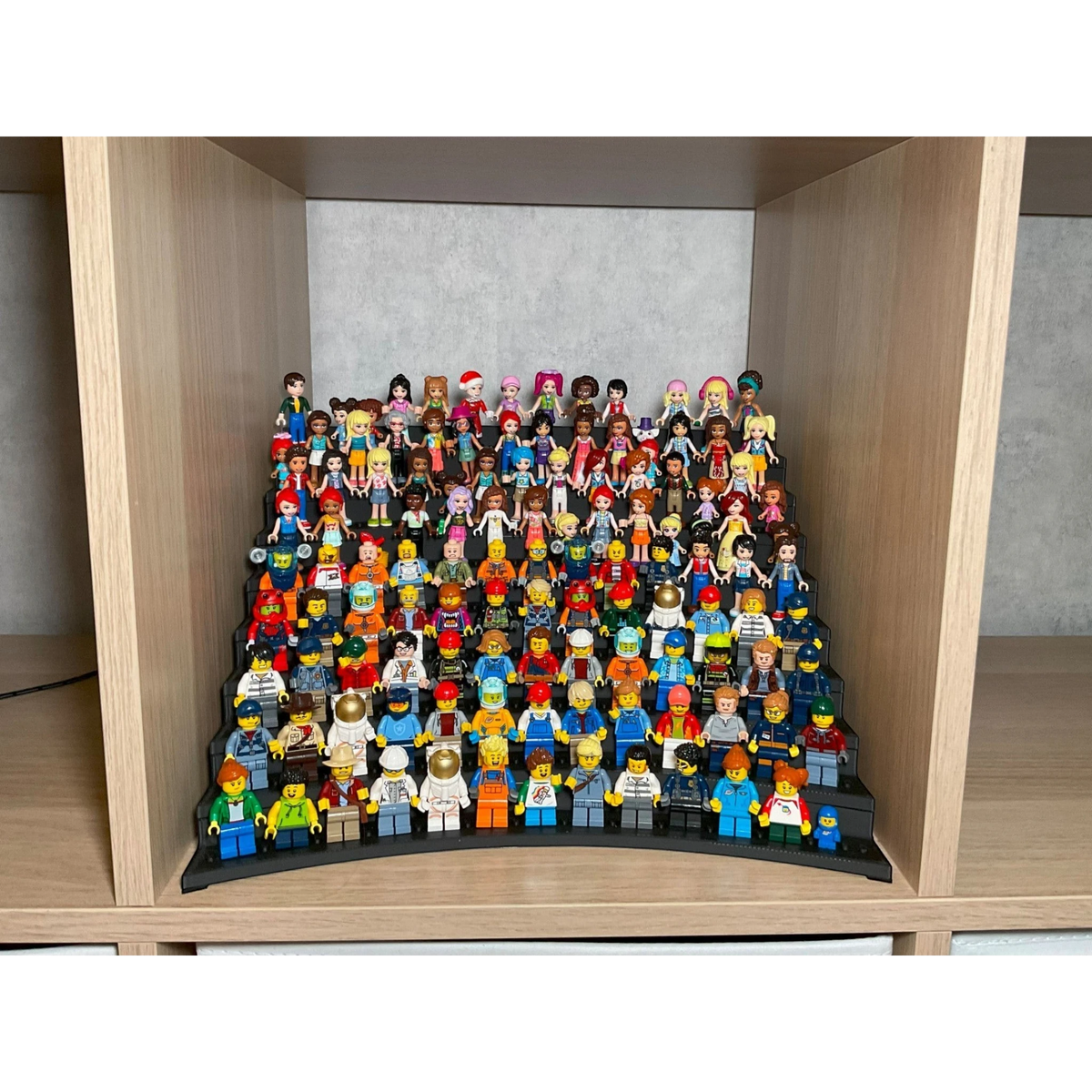 Magicland 3D Büyük Lego Figür Standı, 117 figür kapasiteli, çok katlı siyah sergileme ünitesi üzerinde renkli Lego figürleri.