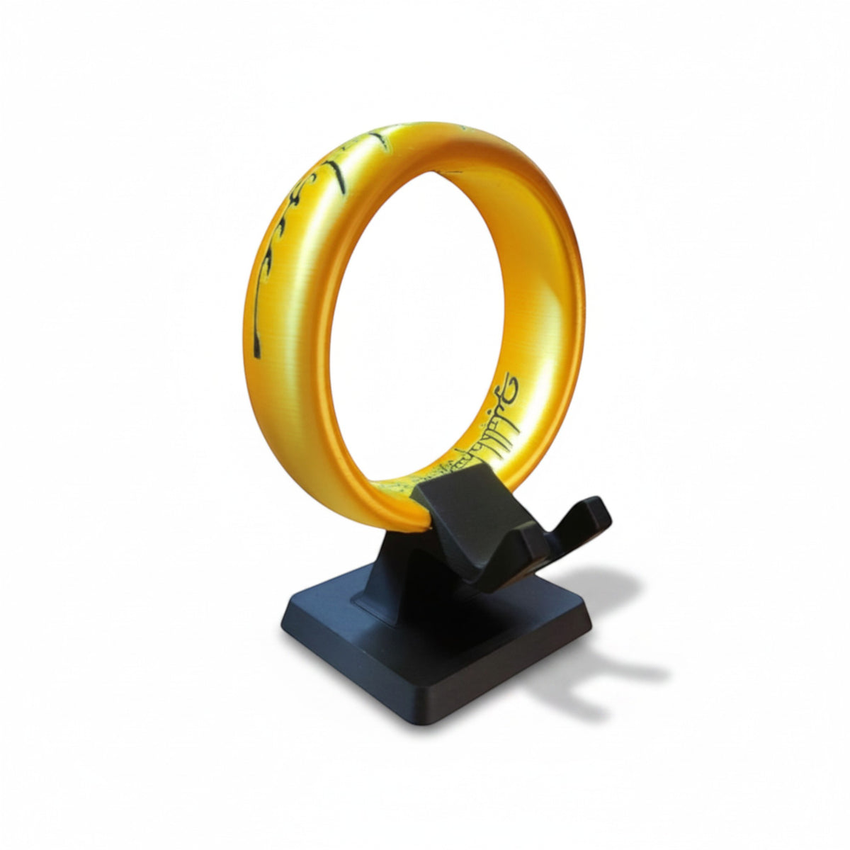 Magicland 3D LOTR Yüzük Kol Tutucu Stant, altın rengi, üzerinde elf yazıları bulunan, siyah bir stant üzerinde duran bir yüzük.
