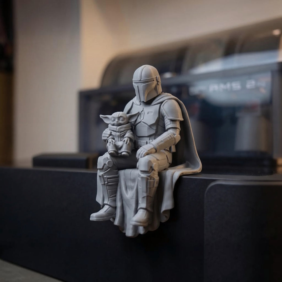 Magicland 3D tasarımı gri renkli, raf kenarına oturan Mandalorian ve Grogu figürü, detaylı 3D baskı Star Wars dekoru