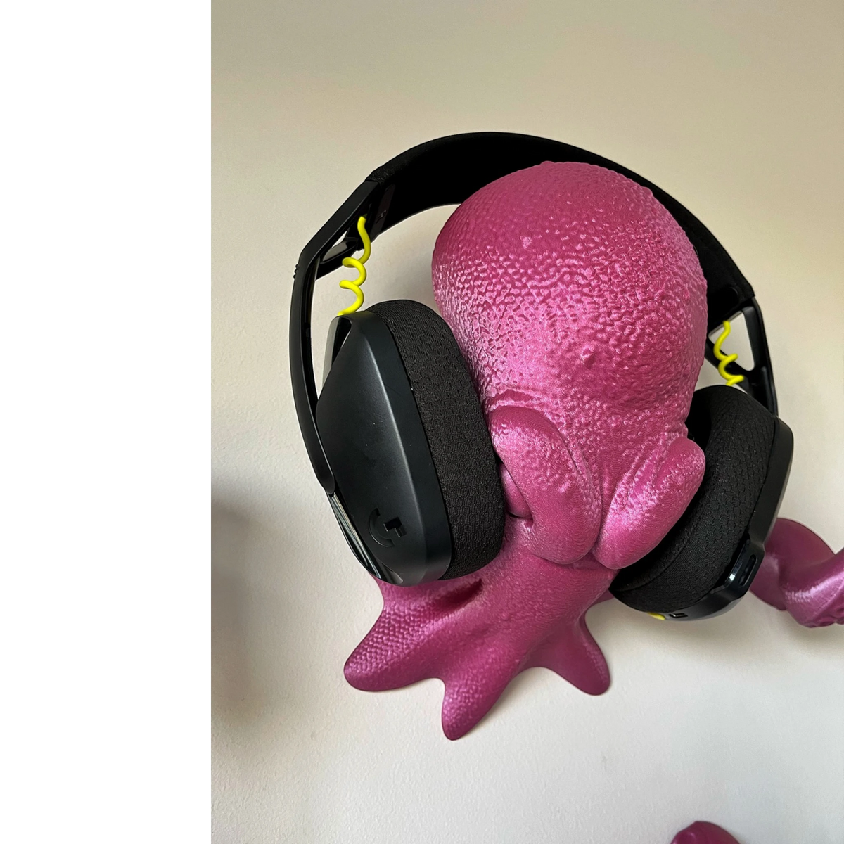 Magicland 3D pink octopus headphone stand with black gaming headphones attached.