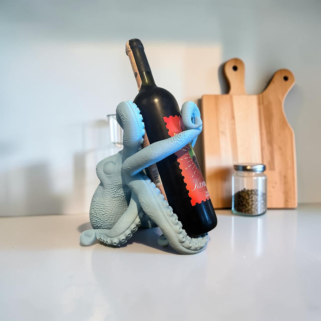 Light blue octopus wine bottle holder by Magicland 3D, featuring detailed tentacles gripping a wine bottle.