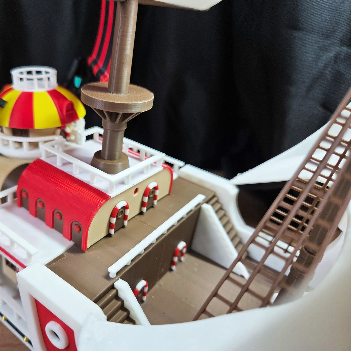 Magicland 3D'nin One Piece Thousand Sunny gemi modeli, kırmızı, sarı ve beyaz renklerde, detaylı güverte ve direk aksesuarlarıyla.