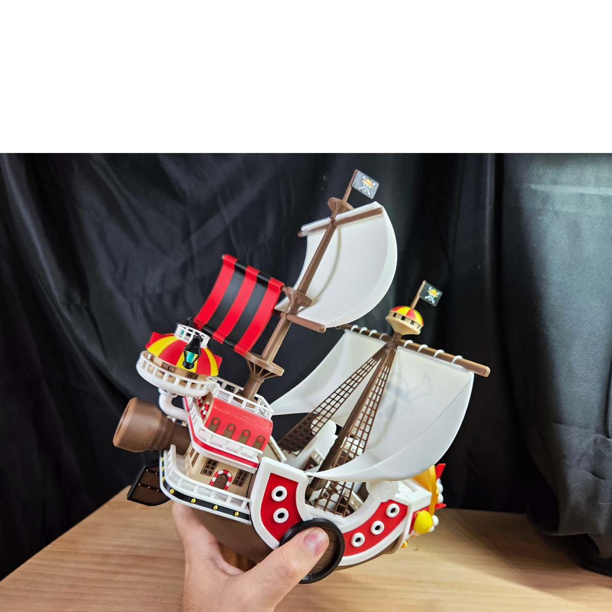 Magicland 3D One Piece Thousand Sunny gemi modeli, kırmızı ve beyaz gövdeli, yelkenleri ve korsan bayrakları ile detaylı.