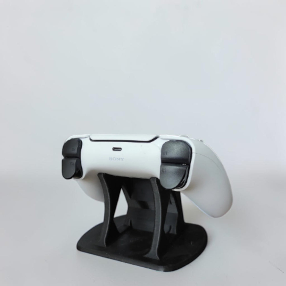 Black decorative stand for PS5 controller, featuring the Sony logo.