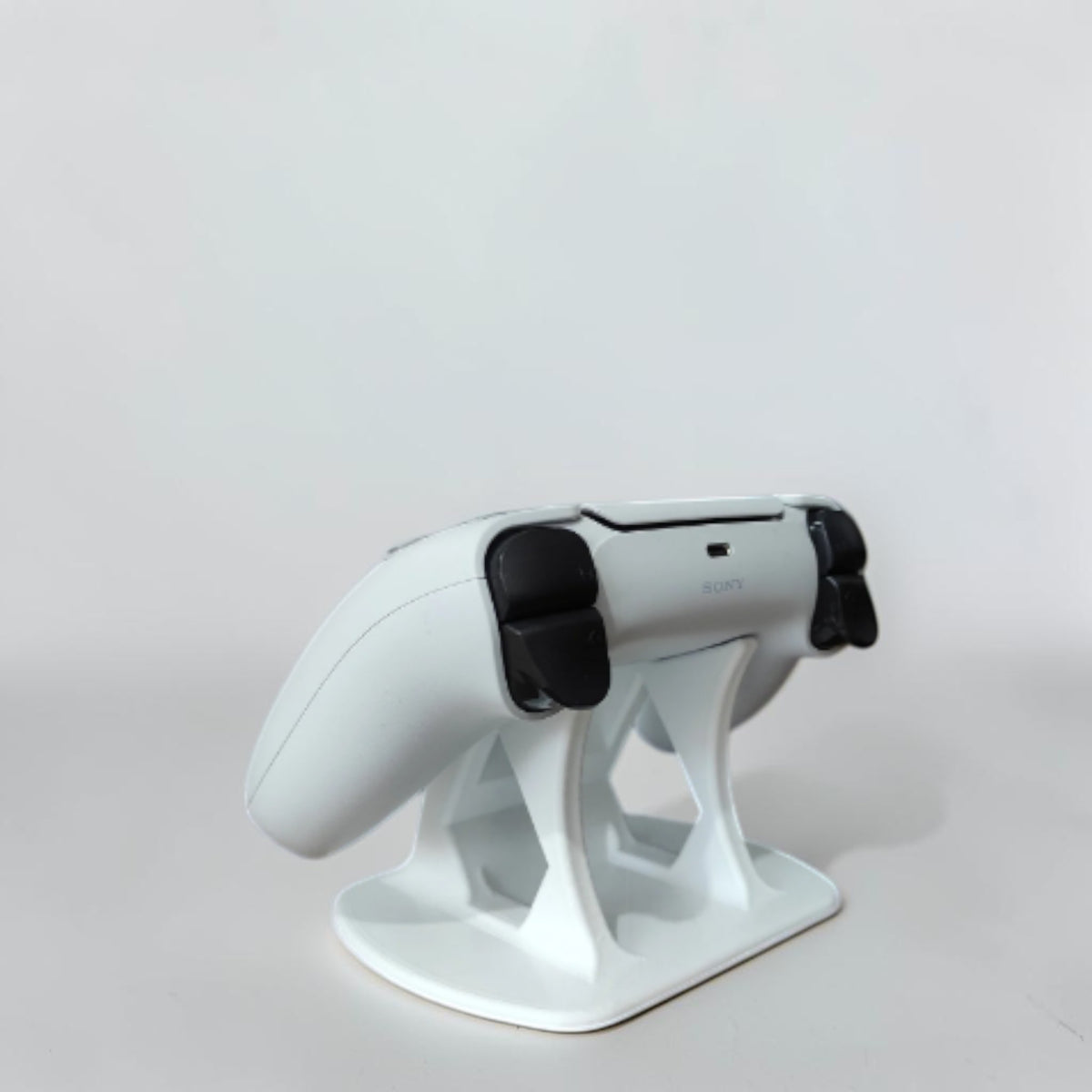 Magicland 3D white PS5 controller stand with PlayStation logo detail. Modern design for gaming setup.