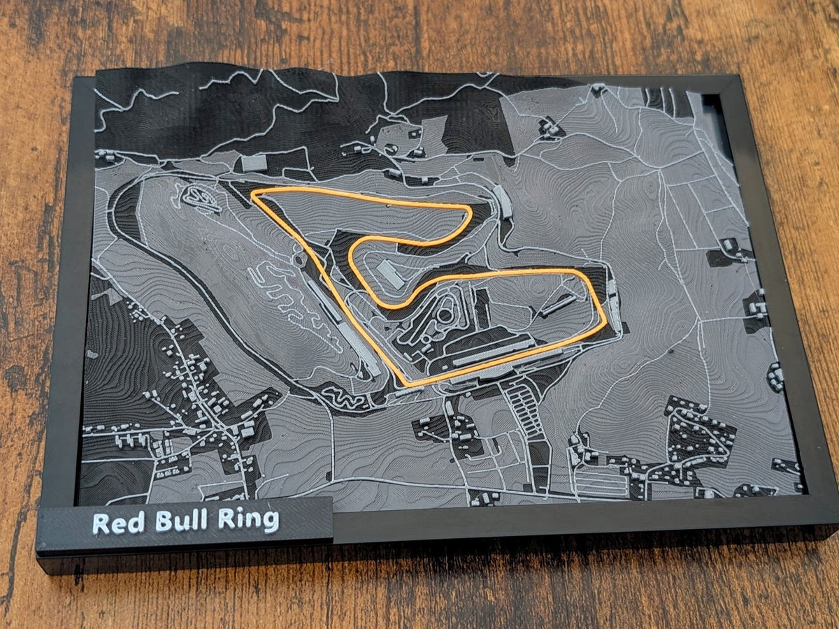 Magicland 3D, 3D kabartma harita üzerinde turuncu renkte vurgulanmış Red Bull Ring pisti ve çevresindeki araziyi gösteren bir tablo.
