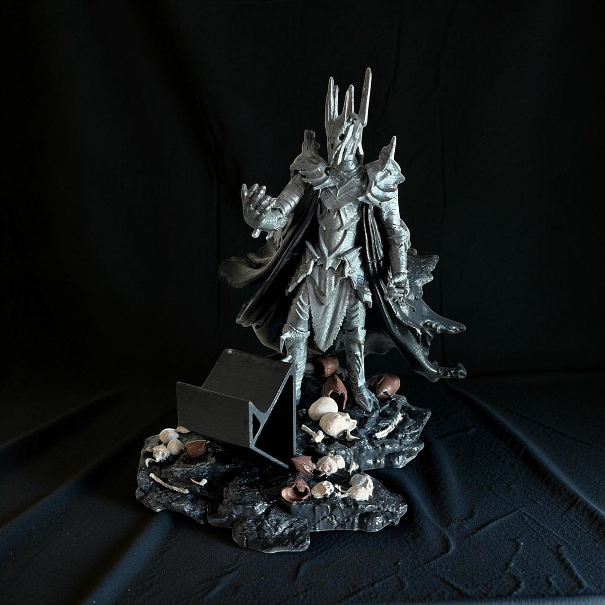 Magicland 3D Sauron figürlü kol tutacağı, zırhlı ve pelerinli figür, kuru kafa ve kemik detaylı kaide üzerinde duruyor.