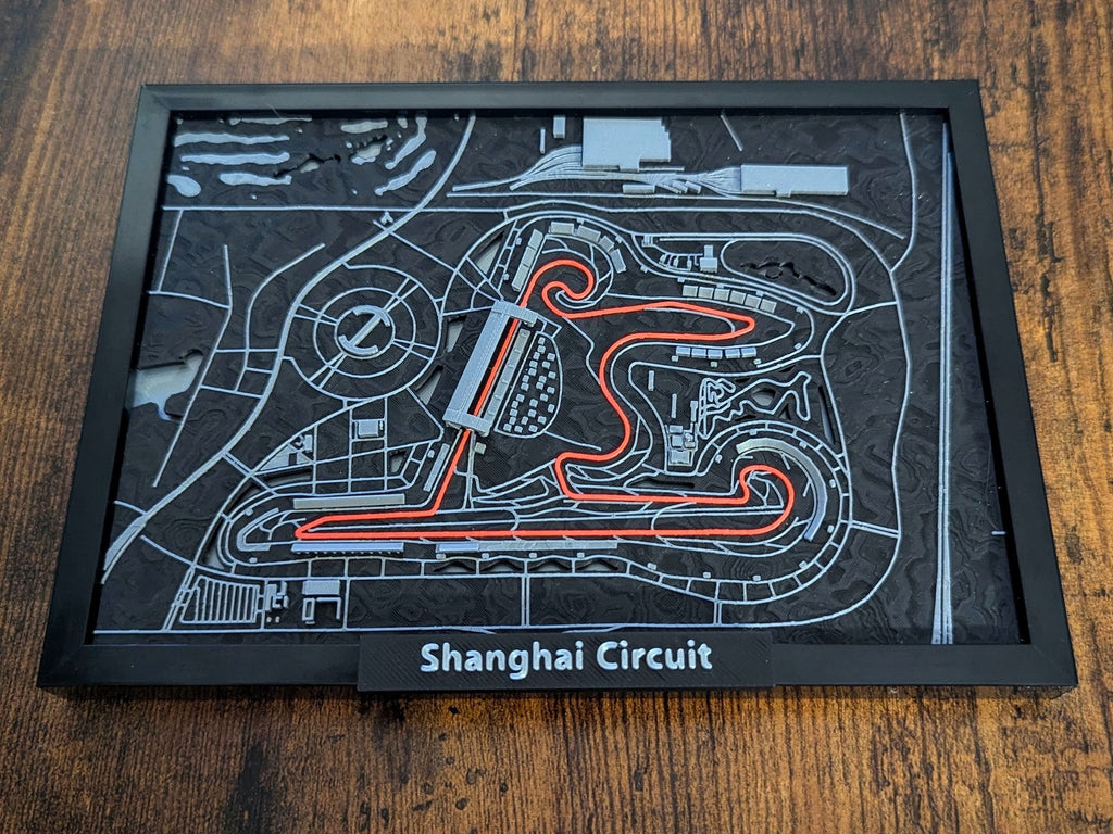 Magicland 3D Shanghai Circuit 3D kabartma haritası, siyah çerçeveli, detaylı pist ve tribünler.