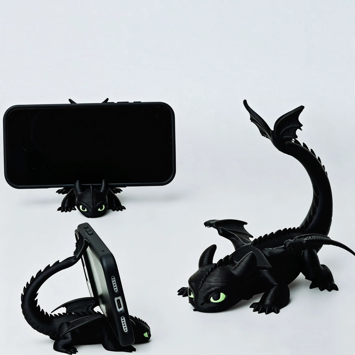 Magicland 3D siyah ejderha figürlü masaüstü telefon standı, yeşil göz detaylı ve kuyruk destekli 3D baskı tasarım.