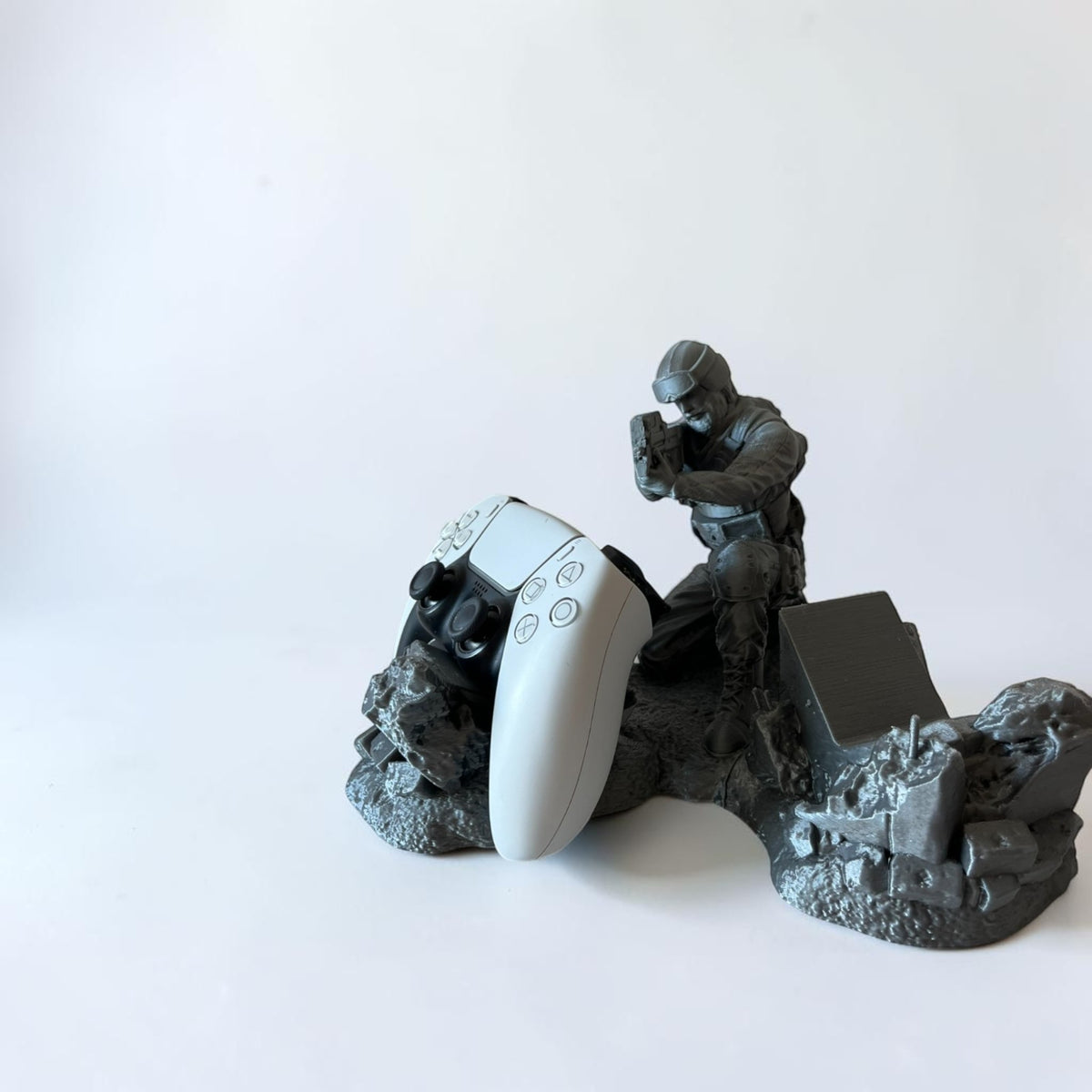 Magicland 3D grey soldier figure controller stand with white PS5 controller.