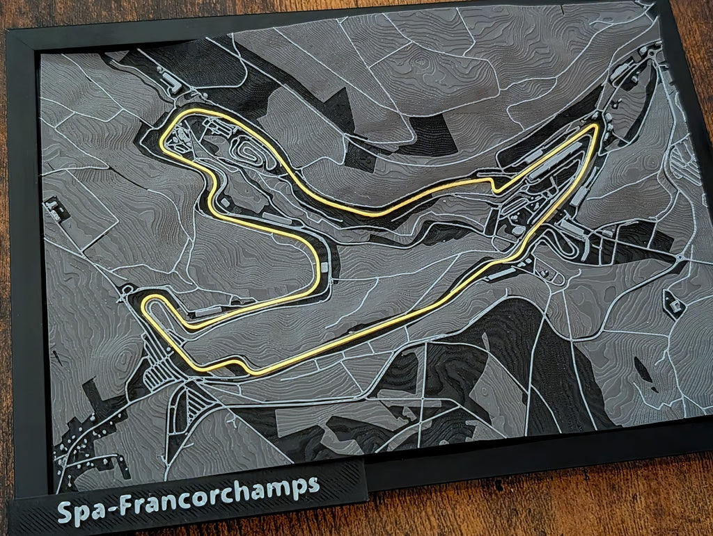 Magicland 3D Spa-Francorchamps F1 pist kabartma haritası, sarı yarış çizgisi ve gri arazi detayları ile.