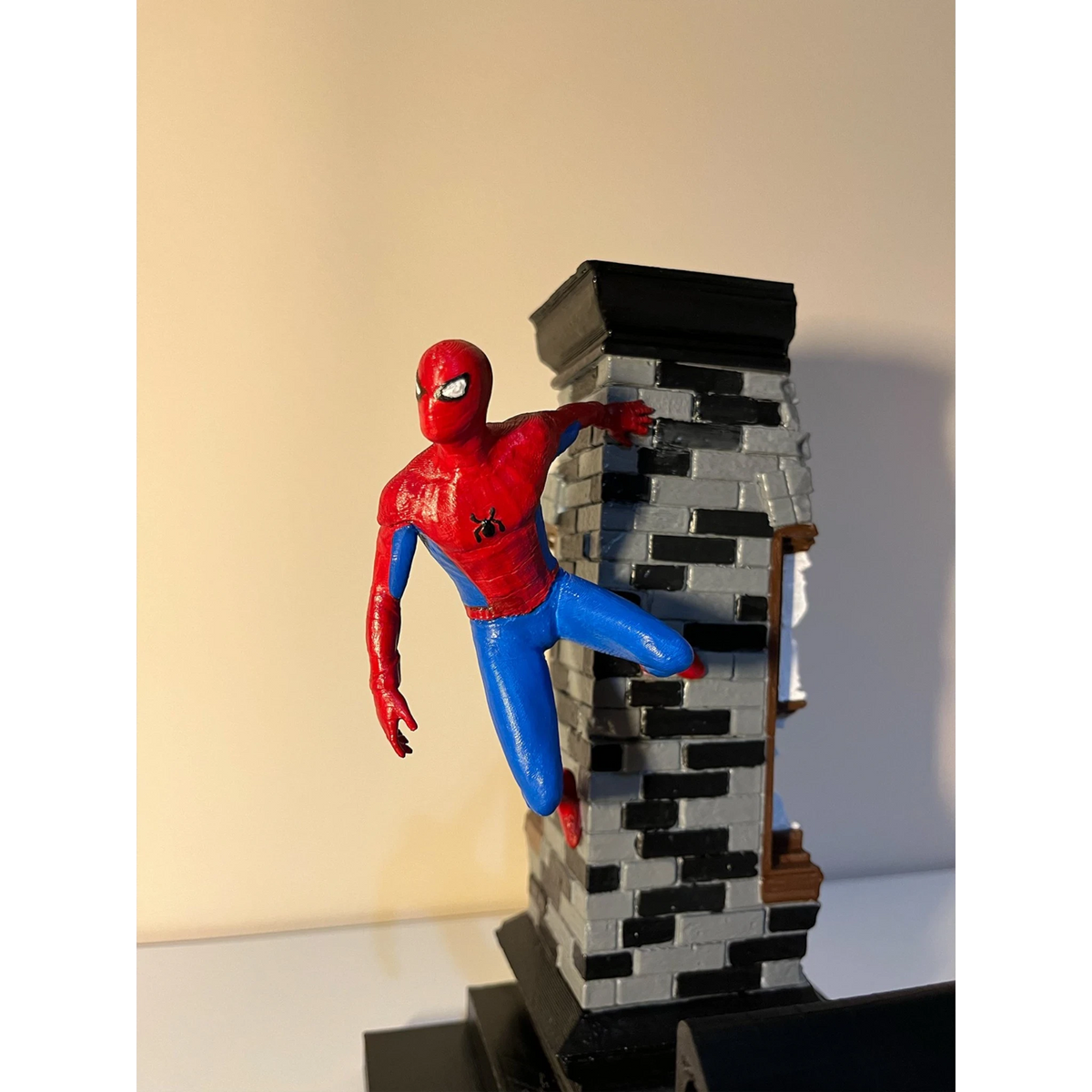Magicland 3D Spiderman özel tasarım kol tutacağı, kırmızı ve mavi kostümlü, tuğla binaya tırmanıyor.