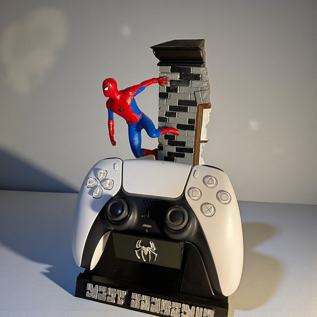 Magicland 3D Spiderman temalı PS5 kontrolcü standı, örümcek adam figürü ve tuğla detaylı, beyaz kontrolcü ile sergileniyor.