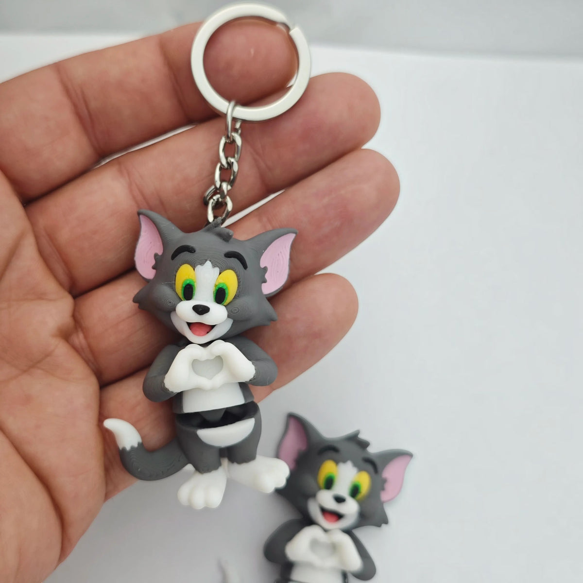 Magicland 3D gri kürk, pembe kulaklı ve kalp yapan elleri olan hareketli Tom figürlü anahtarlık
