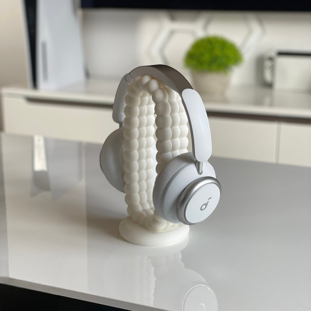 Magicland 3D white bubble headphone stand holding white and silver headphones on a white desk.
