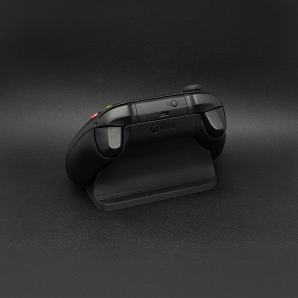 Magicland 3D siyah Xbox kontrolcü standı, sade ve fonksiyonel tasarım, gaming setup aksesuarı.