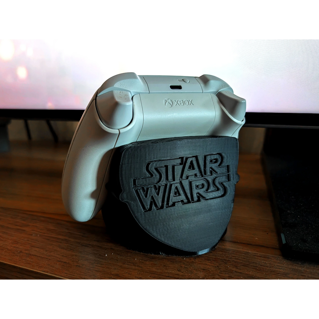 Magicland 3D Star Wars temalı siyah Xbox kontrolcü standı. Beyaz Xbox kontrolcüsü standın üzerinde duruyor.