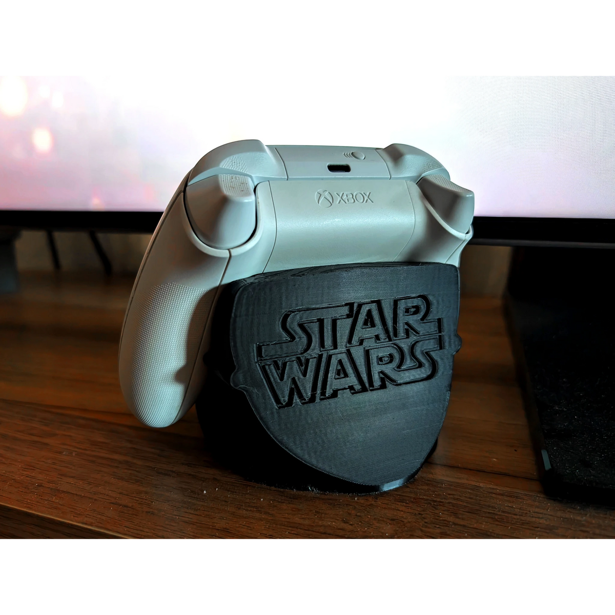 Magicland 3D Star Wars temalı siyah Xbox kontrolcü standı. Beyaz Xbox kontrolcüsü standın üzerinde duruyor.