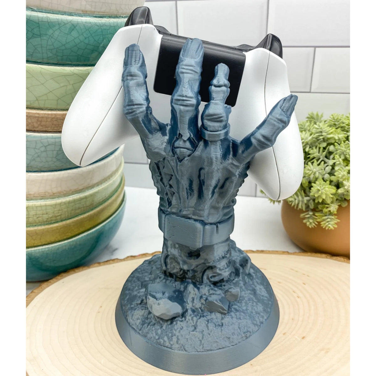 Magicland 3D zombi eli şeklinde gri konsol standı, oyun kumandasını tutuyor.