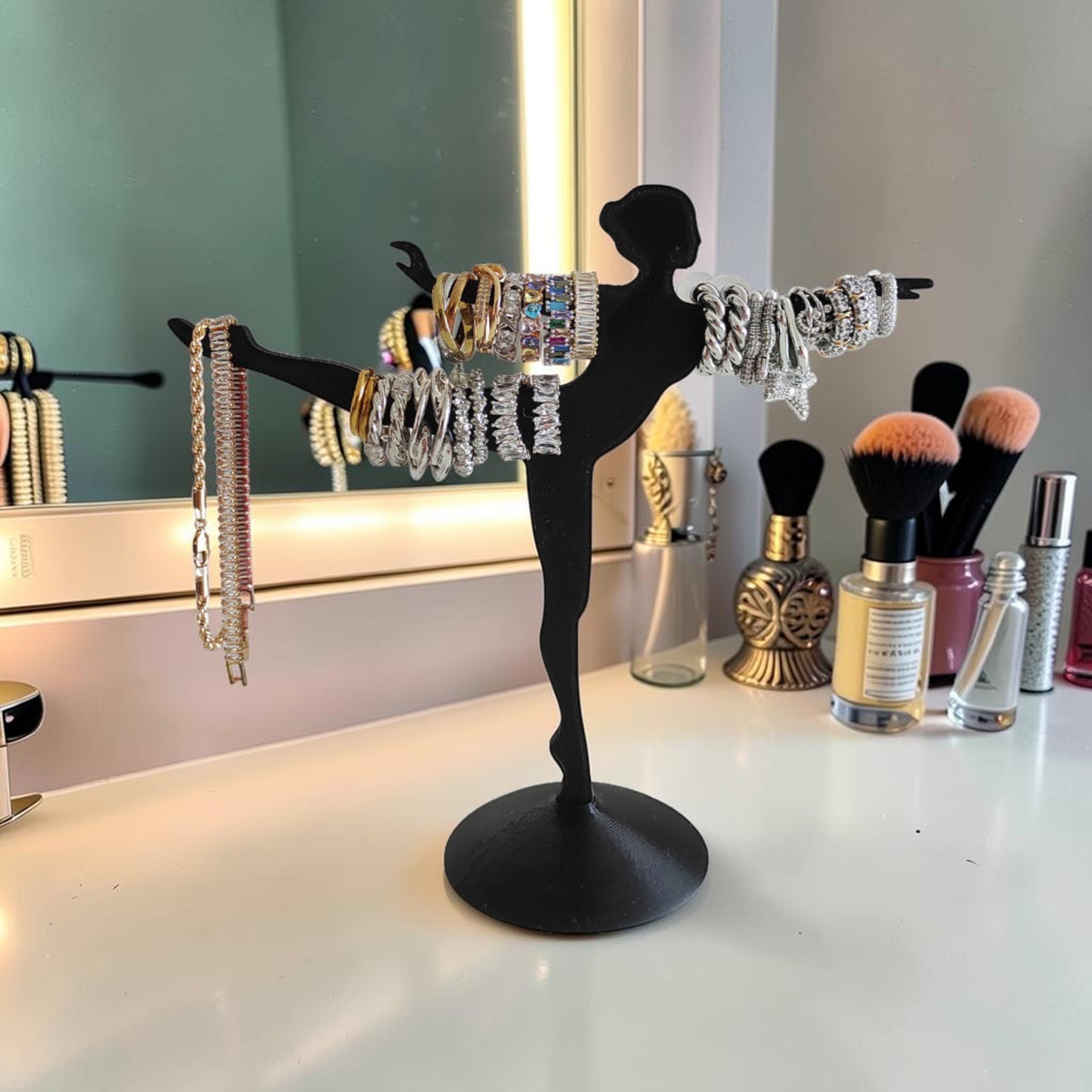 Magicland 3D black ballerina jewelry stand displaying gold and silver bracelets, some with colorful gemstones.
