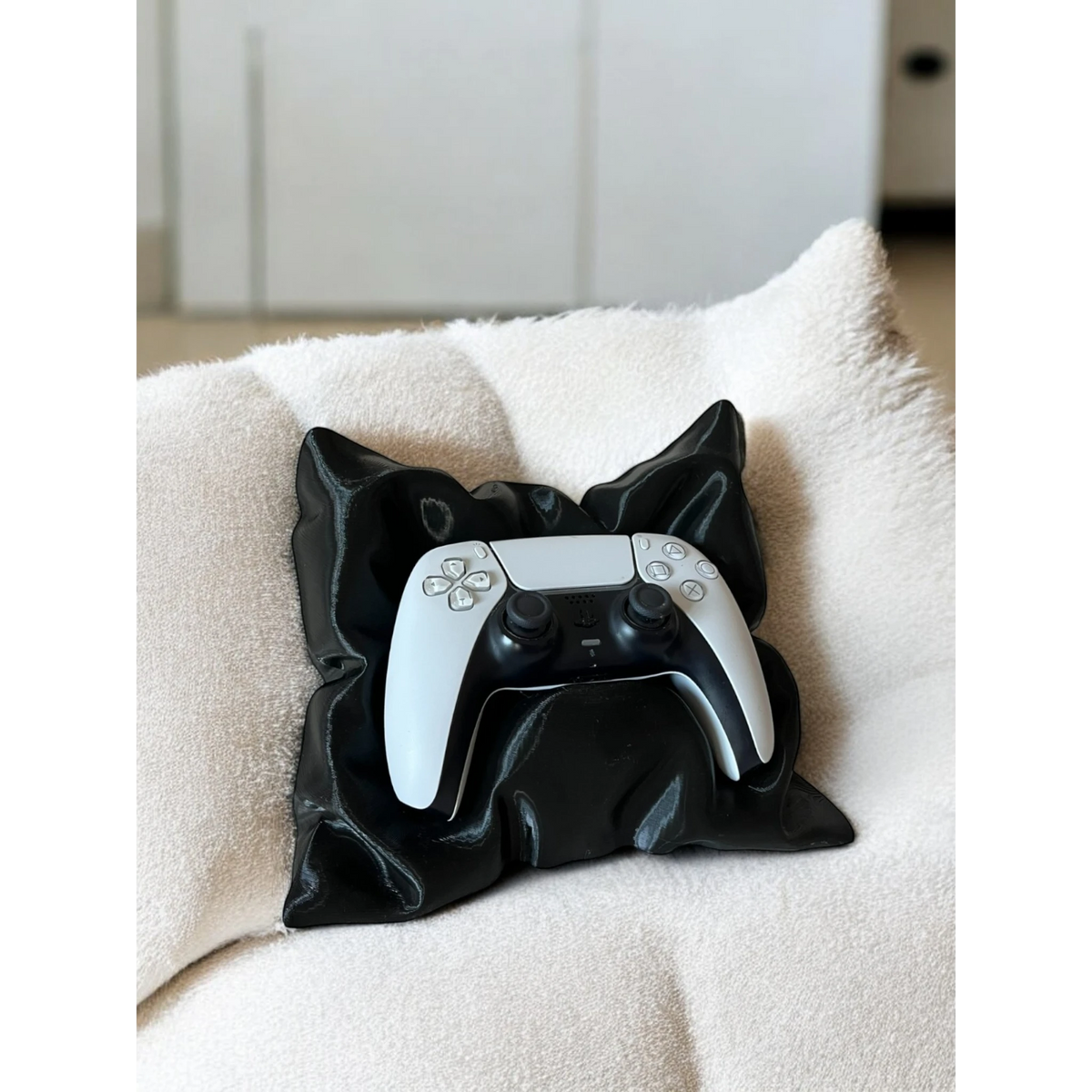 Magicland 3D black pillow-shaped stand holding a white and black game controller on a textured cream surface.