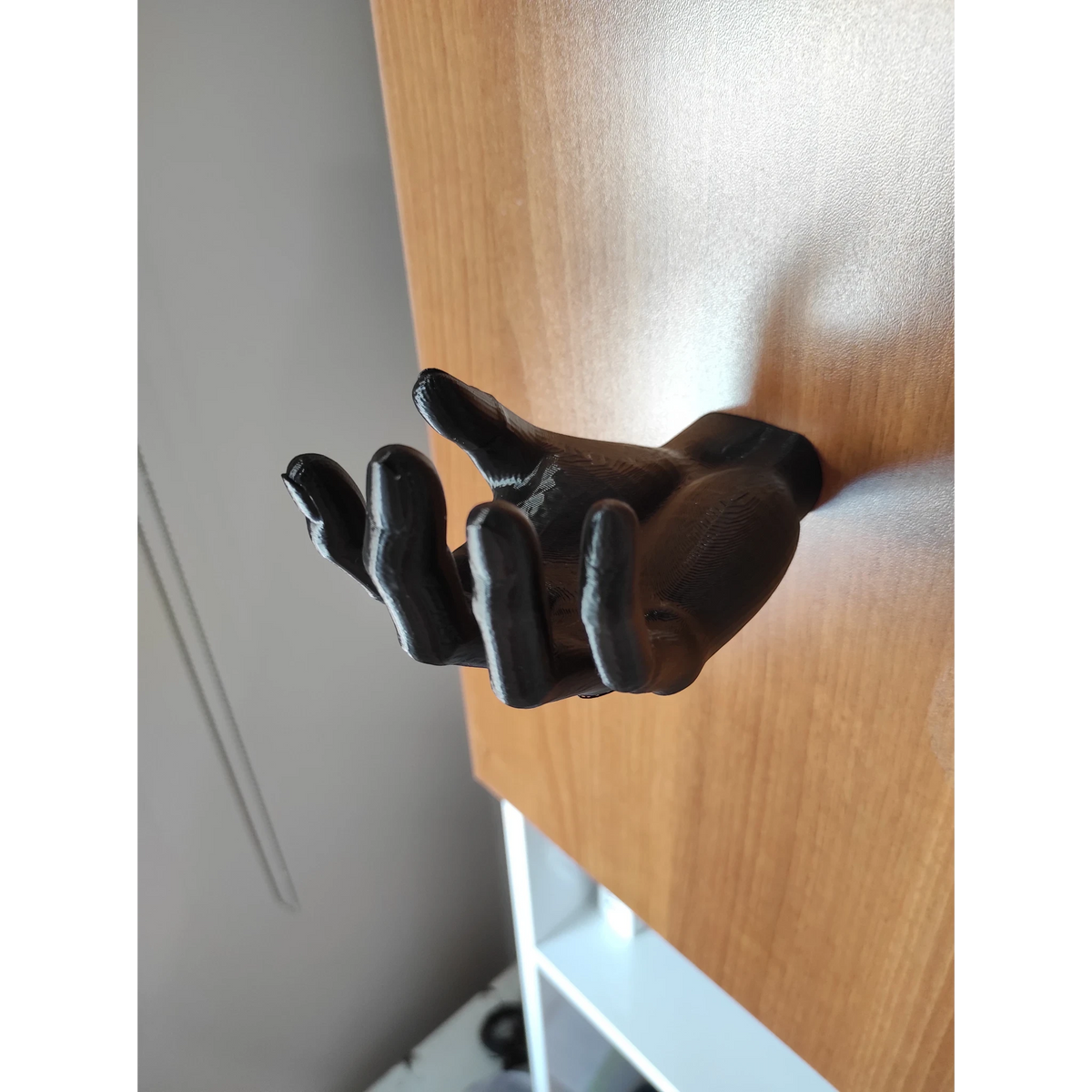 Magicland 3D black hand-shaped headphone stand, ideal for desks and shelves.