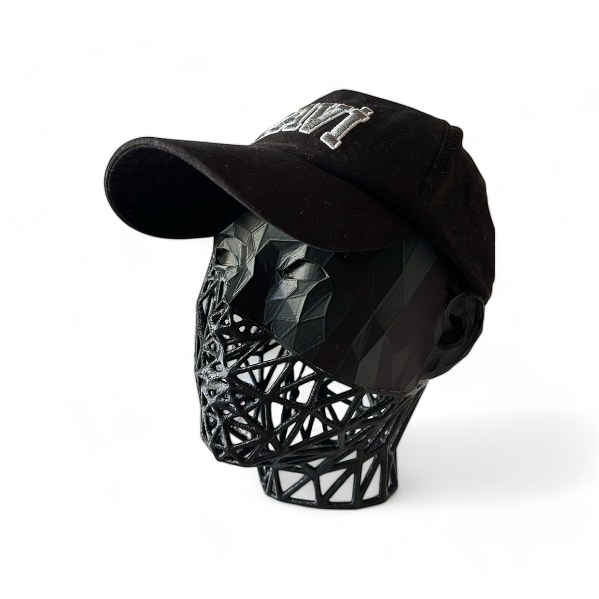 Magicland 3D black Voronoi patterned headphone stand shaped like a face, wearing a black baseball cap.
