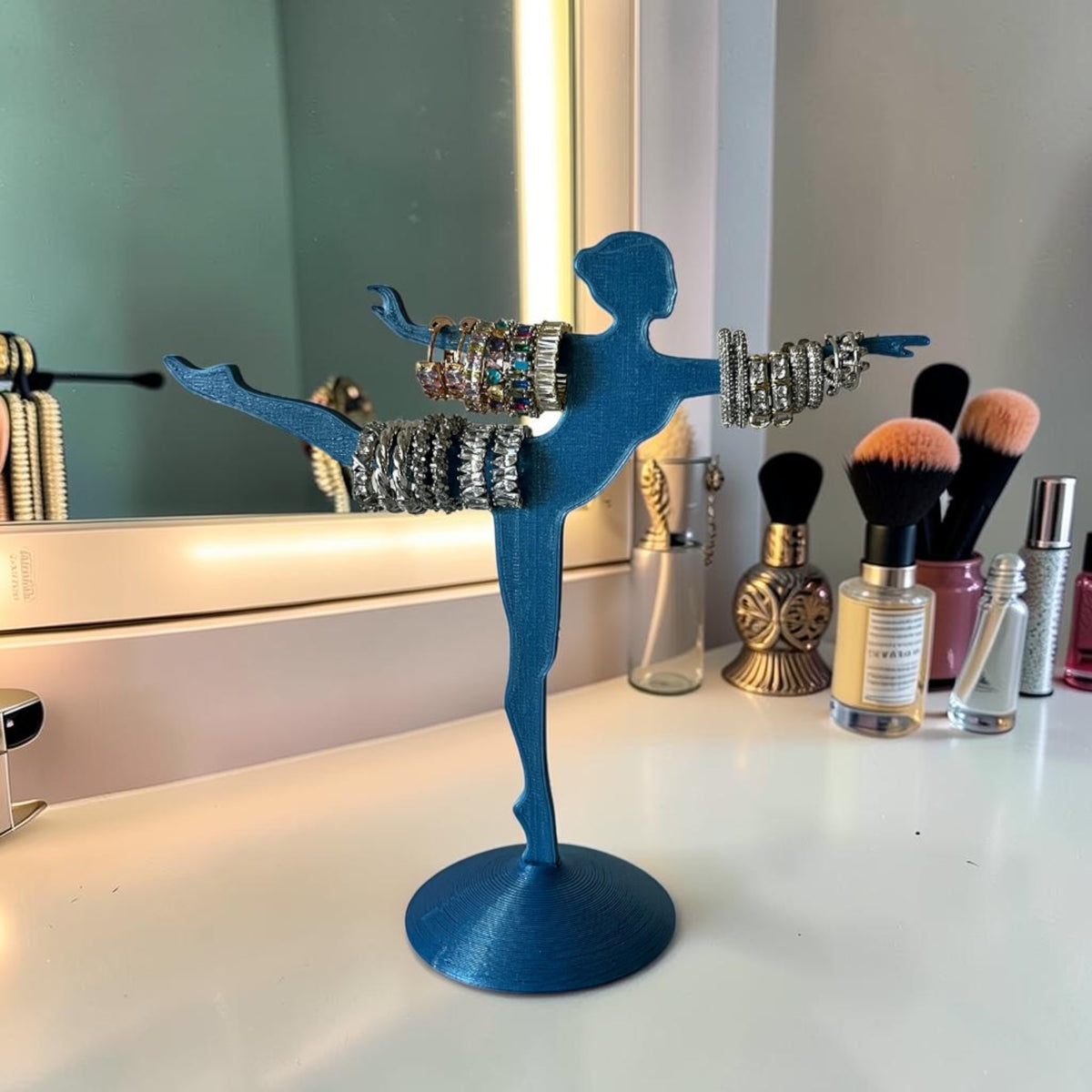 Blue 3D printed ballerina jewelry stand holding bracelets and rings. Decorative accessory.