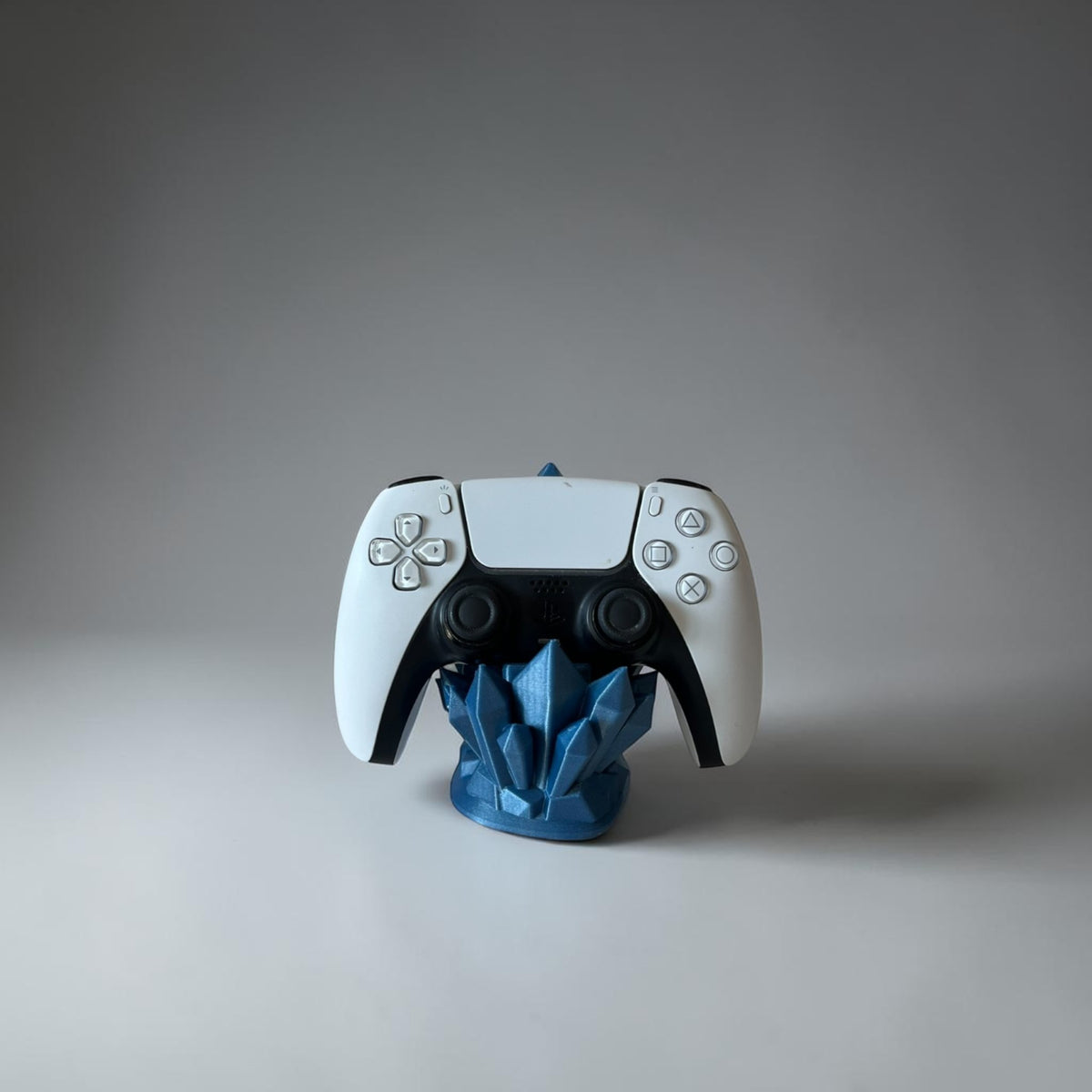 Magicland 3D blue crystal controller stand holding a white PS5 controller on a white background.