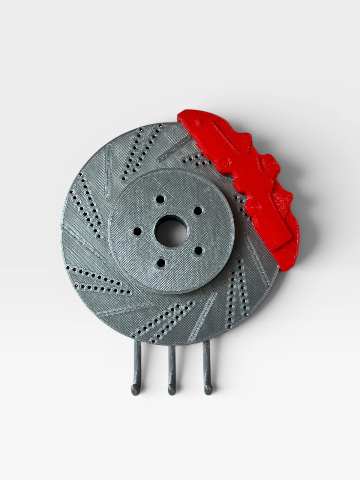 Magicland 3D decorative brake disc key holder with red caliper and grey hooks.