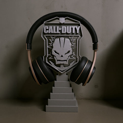 Magicland 3D Call of Duty themed headset stand with skull emblem and tiered base. Black and gold headphones shown.