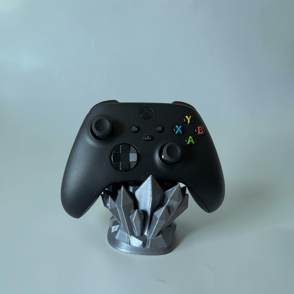 Magicland 3D crystal-shaped controller stand in grey, holding a black Xbox controller.