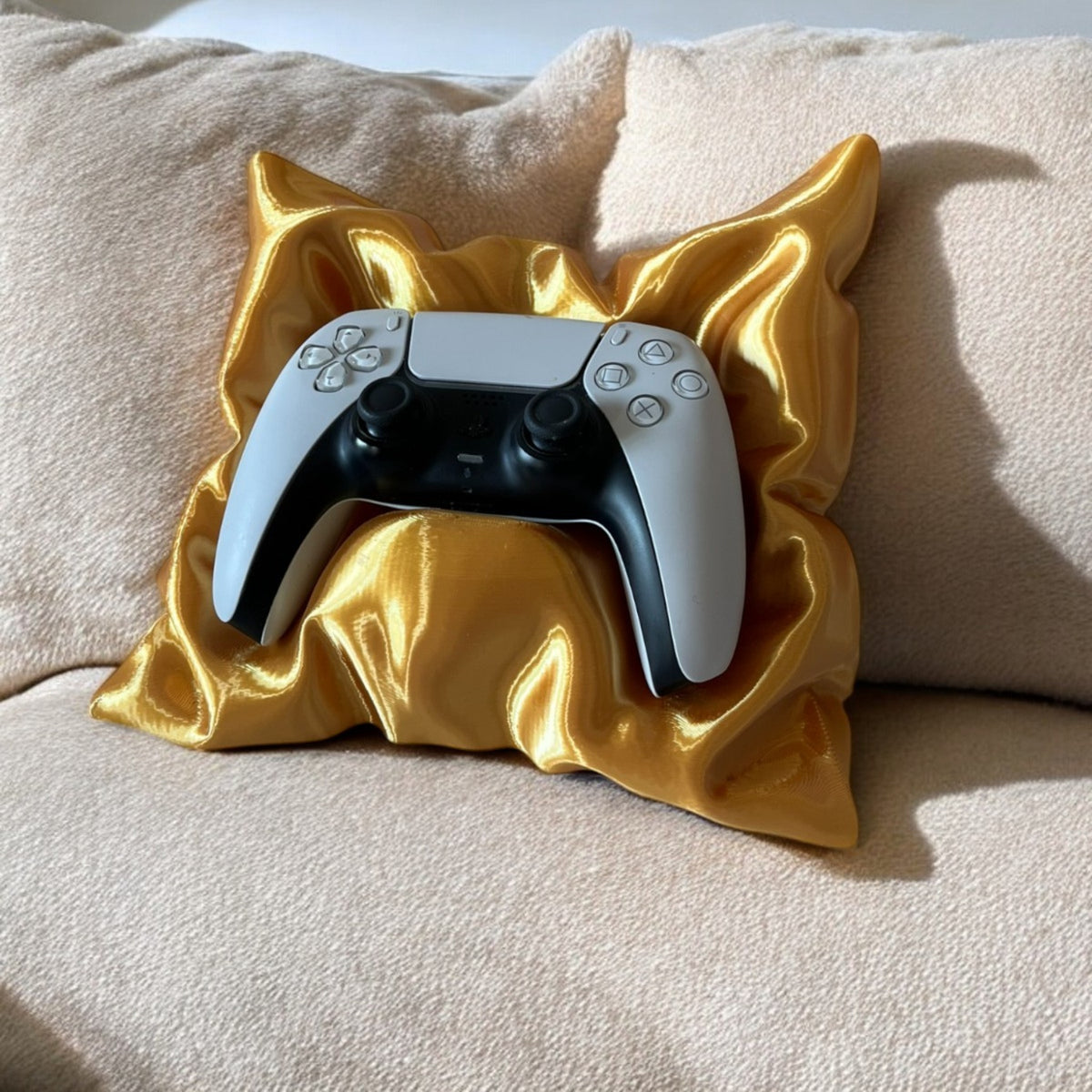 Magicland 3D decorative pillow-shaped stand holding a white and black game controller on a textured couch.
