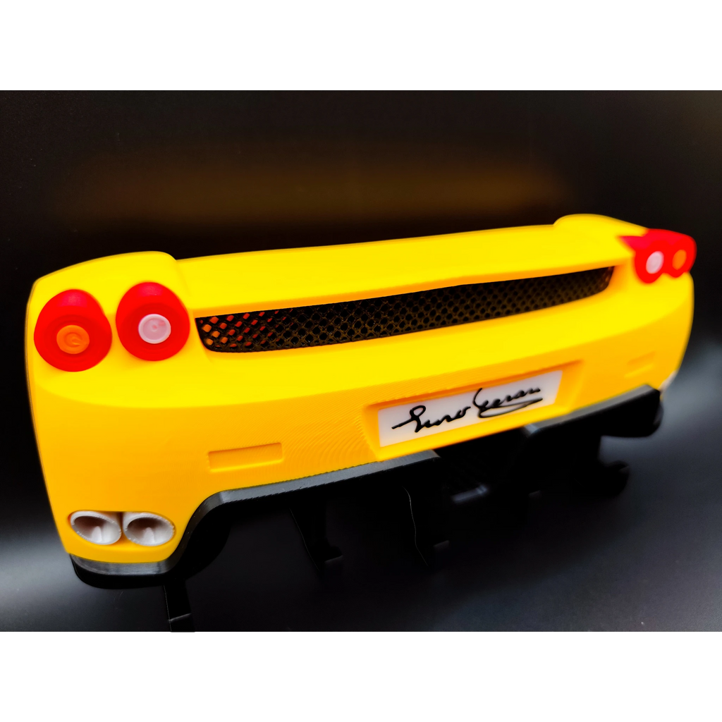 Magicland 3D yellow Ferrari Enzo rear end keychain holder with red taillights and exhaust pipes.
