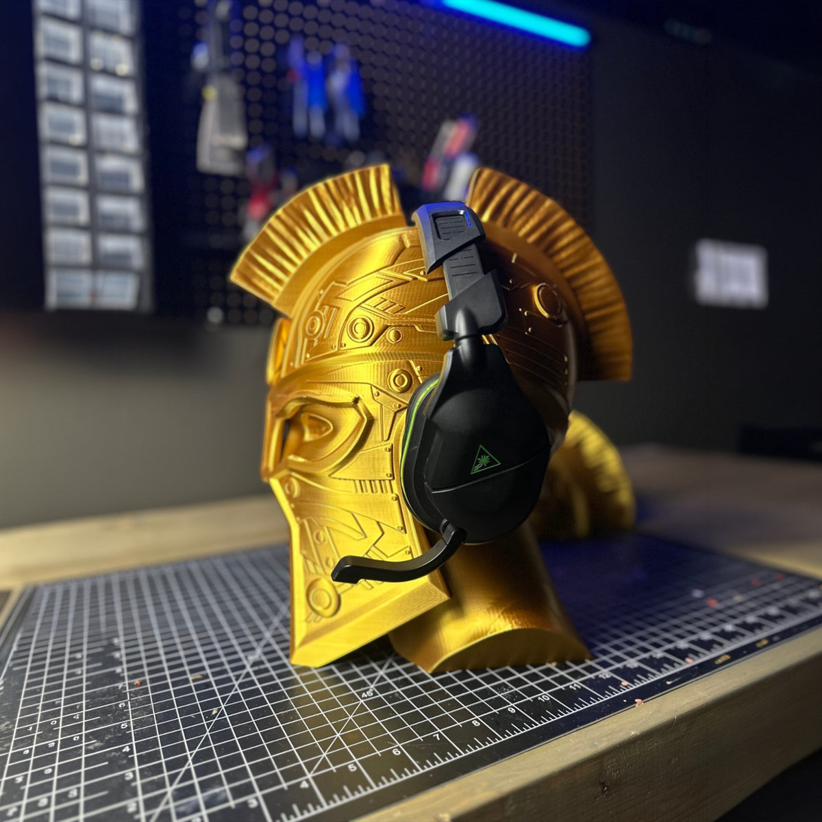 Magicland 3D gold gladiator helmet headphone stand with intricate detailing and a black gaming headset.