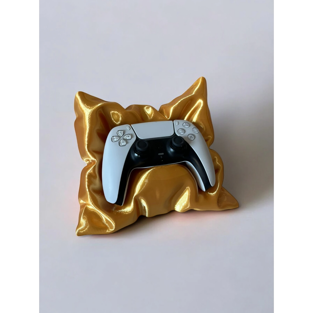 Magicland 3D decorative gold pillow stand holding a white and black PlayStation 5 controller.