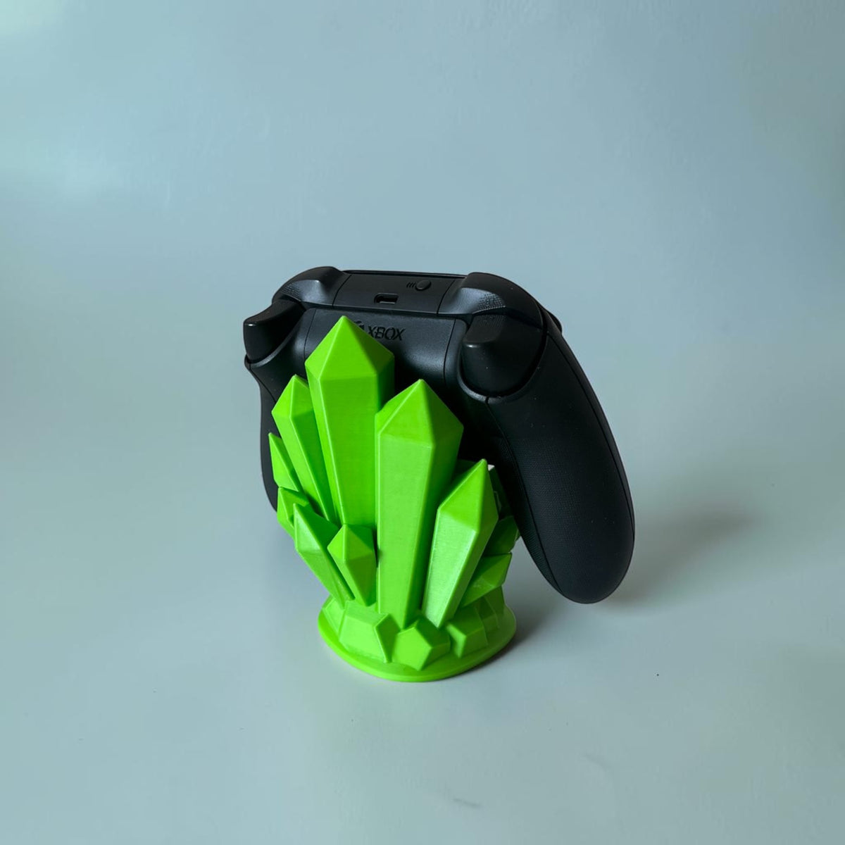 Magicland 3D green crystal controller stand holding a black Xbox controller on a white background.