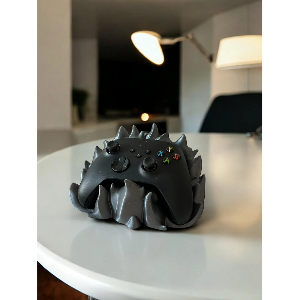 Magicland 3D grey flame-themed controller stand holding a black Xbox controller on a white table.