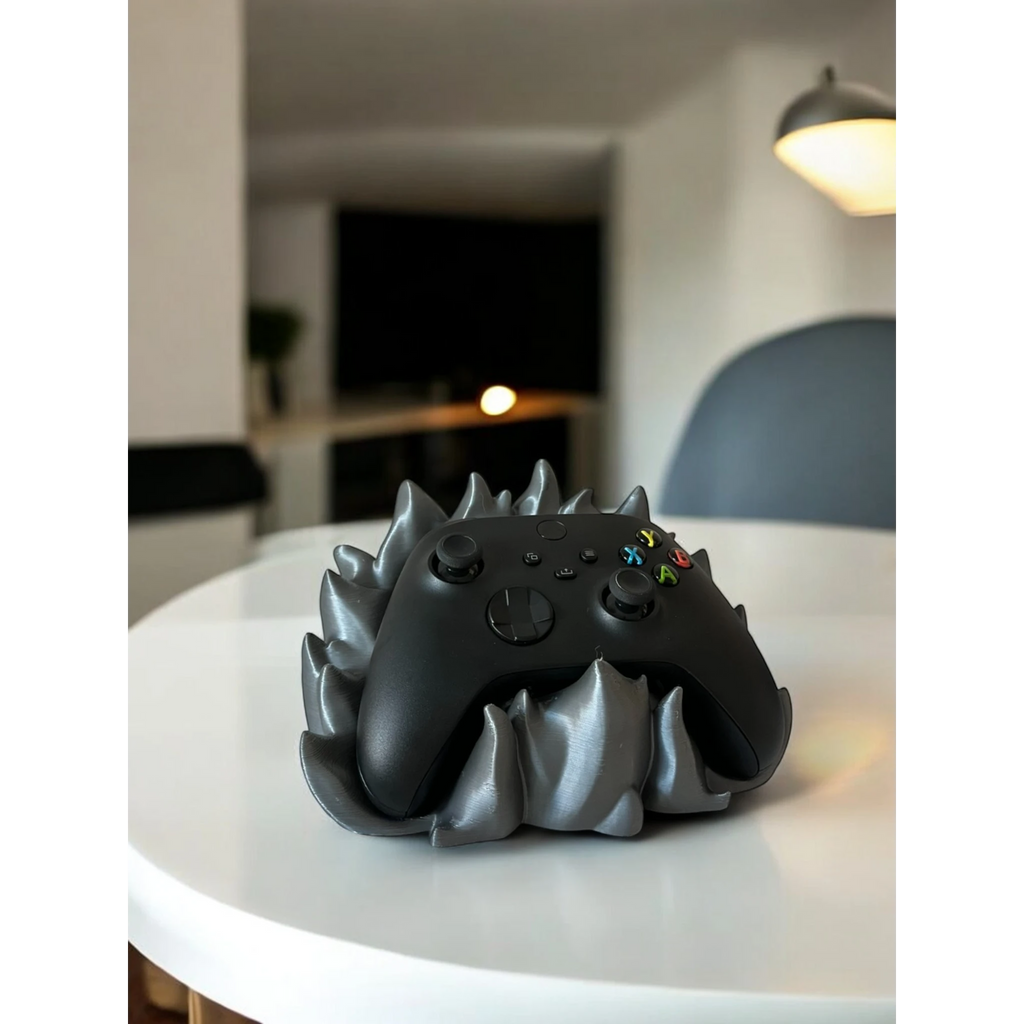 Magicland 3D grey flame-themed controller stand holding a black Xbox controller on a white table.